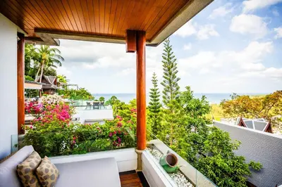 an outdoor balcony with a view of the ocean at Villa Talay in Surin Beach