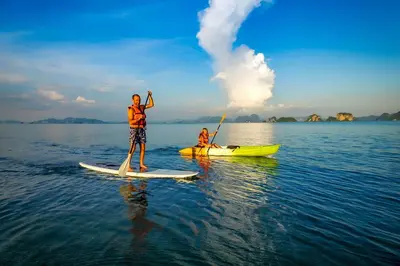 two people on a paddle board in the water at Baan Klong in Ko Yao Noi
