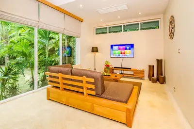a living room with a couch and a tv at Baan Klong in Ko Yao Noi