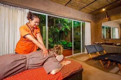 a woman is helping a person laying on a bed at Baan Klong in Ko Yao Noi