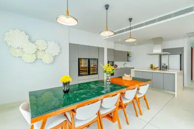 a kitchen with a dining room table with chairs at Baan Kloi III in Ban Na Tai