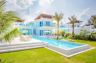 a large white house with a swimming pool in the yard at Baan Kloi in Ban Na Tai