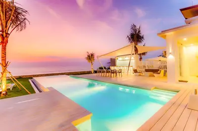 a house with a swimming pool next to the ocean at Baan Kloi in Ban Na Tai