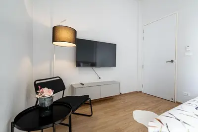 a living room with a table and a tv at COMFORTABLE RENOVATED 2BR TownHouse5 MonkeyHill in Ban Sam Kong