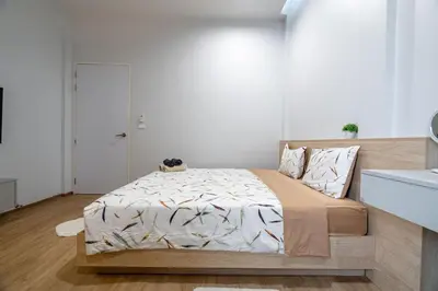 a bedroom with a large bed in a white room at COMFORTABLE RENOVATED 2BR TownHouse5 MonkeyHill in Ban Sam Kong