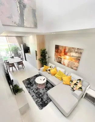 a living room with a white couch and yellow pillows at COMFORTABLE RENOVATED 2BR TownHouse5 MonkeyHill in Ban Sam Kong
