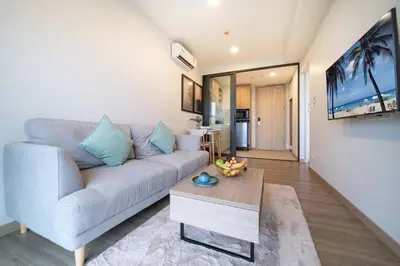 a living room with a couch and a table at Fairway Escape - Golf View 1BR with Balcony in Laguna in Laguna Phuket