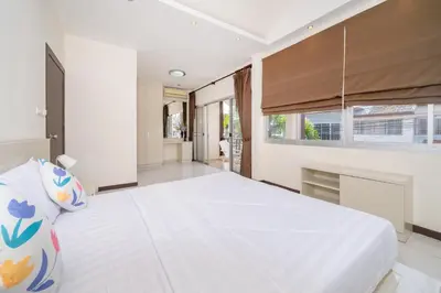 a bedroom with a large white bed and a window at Laguna Townhouse with Jacuzzi bathtub, Bang Tao beach in Laguna Phuket