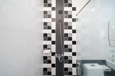 a bathroom with a black and white checkered wall at Laguna Townhouse with Jacuzzi bathtub, Bang Tao beach in Laguna Phuket