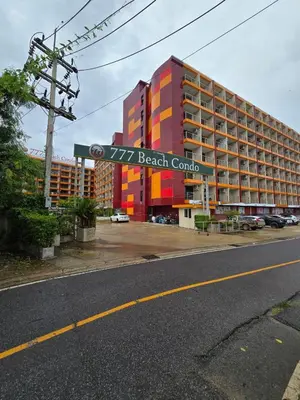 a building with a beach condo sign in front of it at 777 Beach Condotel in Mai Khao Beach