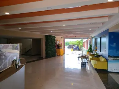 a lobby with a yellow couch in a building at 777 Beach Condotel in Mai Khao Beach