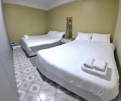 a bedroom with two beds with towels on them at 113 Yellow House Hostel in Phuket Town