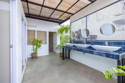 a bathroom with two sinks and two mirrors at 113 Yellow House Hostel in Phuket Town