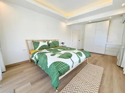 a bedroom with a bed with a green and white comforter at 2 Bedroom Pool Villa in Kamala in Kamala Beach