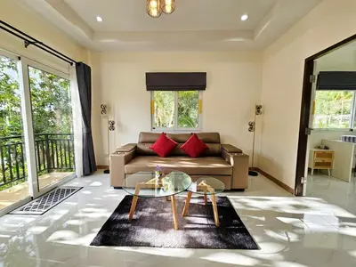 a living room with a couch and a glass table at 2 Bedroom Pool Villa Green View in Kamala Beach