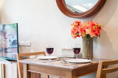 a table with two glasses of wine and a vase of flowers at \u4f18\u9009\u623f\u6e90 220\u53f7\u82ad\u4e1c\u6d77\u6ee9\u7cbe\u88c5\u516c\u5bd35\u5206\u949f\u6d77\u6ee910\u5206\u949f\u9152\u5427\u8857 \u65c5\u884c\u5ea6\u5047\u9996\u9009 in Patong Beach