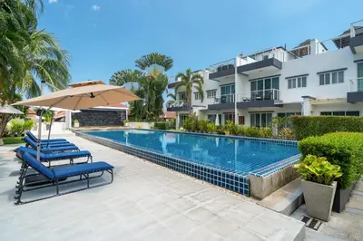 a swimming pool with two lounge chairs and an umbrella at Sunny Paradise Kamala Beach in Kamala Beach