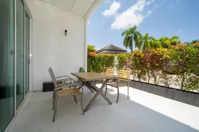 a patio with a wooden table and chairs on a balcony at Sunny Paradise Kamala Beach in Kamala Beach