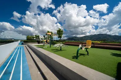 a view of a swimming pool with chairs and grass at Skypark Laguna Bang Tao Beach in Laguna Phuket