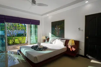 a bedroom with a bed and a large window at Noksawan Villa by G Estate in Rawai Beach