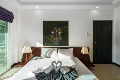 a bedroom with a bed with a dress on it at Noksawan Villa by G Estate in Rawai Beach