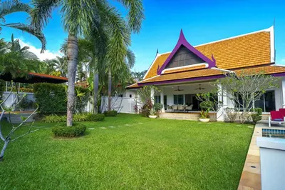 a house with a yard with palm trees at Noksawan Villa by G Estate in Rawai Beach