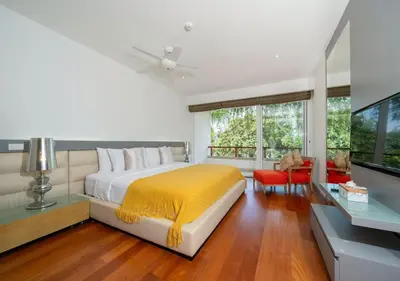a bedroom with a bed with a yellow blanket on it at JSD Prime Property-Surin Beach in Surin Beach