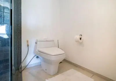 a white toilet in a bathroom with a roll of toilet paper at JSD Prime Property-Surin Beach in Surin Beach
