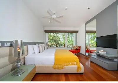 a bedroom with a large bed and a television at JSD Prime Property-Surin Beach in Surin Beach