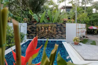 a picture of a swimming pool with a painting on the wall at Jampun Pool Villa in Klong Muang Beach