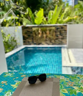 a bow tie sitting on a table next to a swimming pool at Jampun Pool Villa in Klong Muang Beach