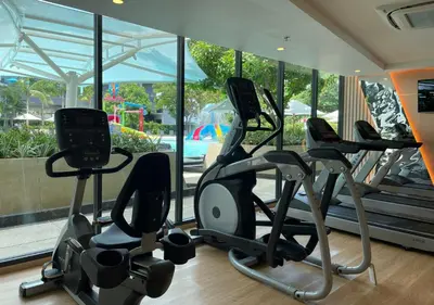 a gym with several cardio machines in front of a window at Luxurious 5-star Apartment in Rawai Beach
