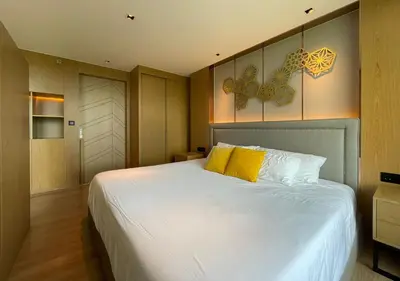 a bedroom with a large white bed with yellow pillows at Luxurious 5-star Apartment in Rawai Beach