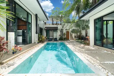 an infinity pool in the backyard of a house at Wings Villa Laguna Bang Tao Beach Phuket in Ban Pak Lak