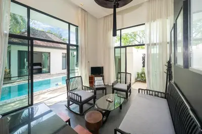 a living room with large windows and a pool at Wings Villa Laguna Bang Tao Beach Phuket in Ban Pak Lak