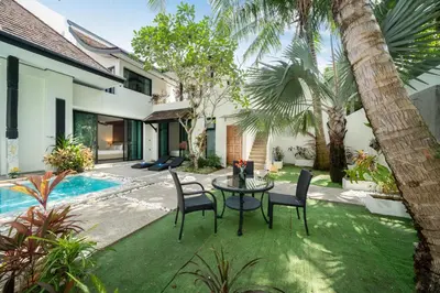 a patio with a table and chairs and a pool at Wings Villa Laguna Bang Tao Beach Phuket in Ban Pak Lak
