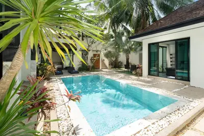 a swimming pool in front of a house at Wings Villa Laguna Bang Tao Beach Phuket in Ban Pak Lak