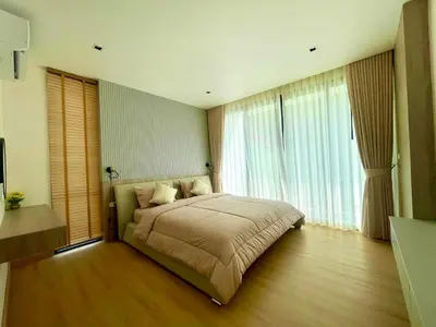 a bedroom with a large bed and large windows at Mali Thai Villa - Just 5 minutes to Kata Beach in Kata Beach