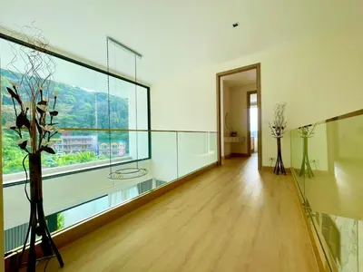 a living room with a large window and a wooden floor at Mali Thai Villa - Just 5 minutes to Kata Beach in Kata Beach