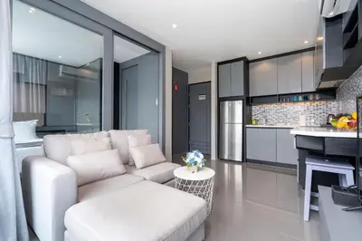 a living room with a white couch and a kitchen at Tropics Kamala Hill View Apartment CTG D704 near Beach and Fantasea in Kamala Beach