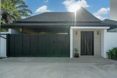 a house with a green gate and a garage at Bua Sawan - 4 Bedrooms Pool Villa in Ban Pak Lak