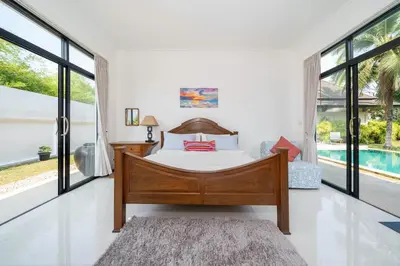 a bedroom with a bed and a swimming pool at Bua Sawan - 4 Bedrooms Pool Villa in Ban Pak Lak
