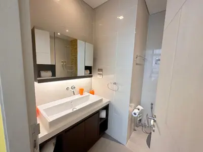 a white bathroom with a sink and a mirror at Cassia Loft Laguna Phuket Bang Tao Beach in Laguna Phuket