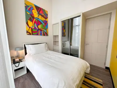 a bedroom with a white bed and a painting on the wall at Cassia Loft Laguna Phuket Bang Tao Beach in Laguna Phuket