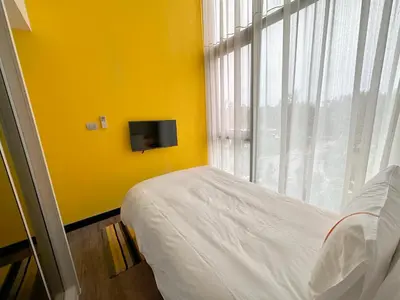 a bedroom with a bed and a yellow wall at Cassia Loft Laguna Phuket Bang Tao Beach in Laguna Phuket