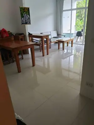 a living room with wooden tables on a tiled floor at Grand kamala falls in Kamala Beach