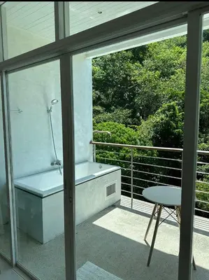 a bathroom with a tub and a table and a window at Grand kamala falls in Kamala Beach