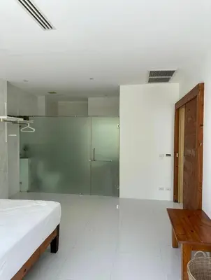 a white room with a bed and a glass wall at Grand kamala falls in Kamala Beach