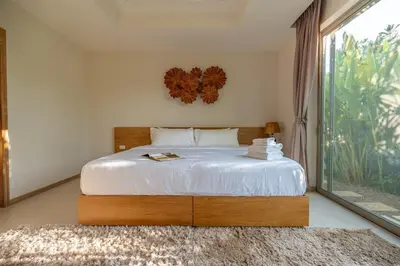 a bedroom with a bed and a large window at Villa Allamanda 3 Bdrm Best Location Bangtao Beach VVPHU88 in Phuket