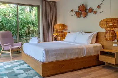 a bedroom with a bed and a chair and a window at Villa Allamanda 3 Bdrm Best Location Bangtao Beach VVPHU88 in Phuket